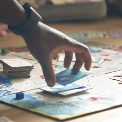 image of hand drawing a card while playing a board game