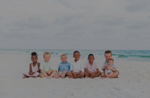 Adopted children sitting on the beach