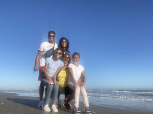 family stands on the beach