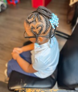 Girl with braids sits in salon chair