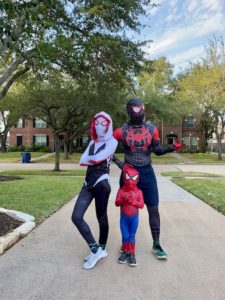 family poses with matching spiderman halloween costumes