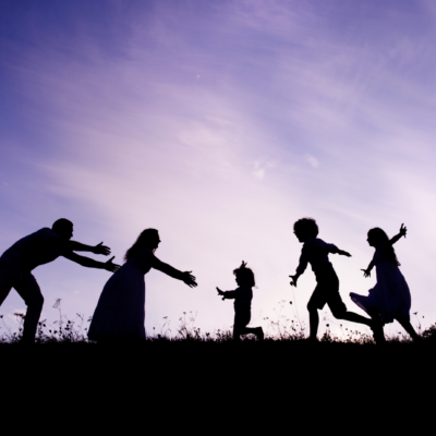 silhouette of a family of five in a meadow